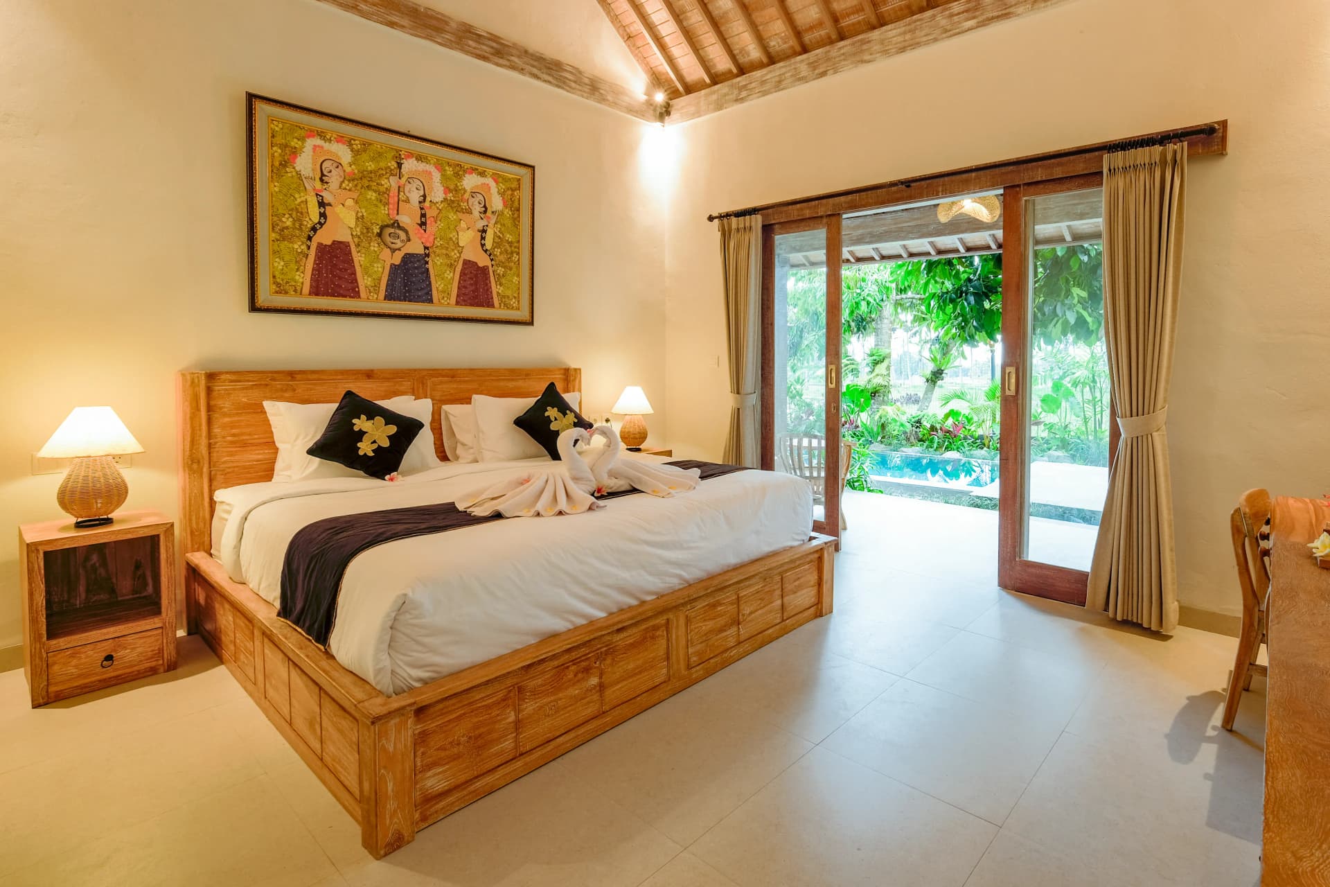 Queen size bed with bedside lamps in private villa Ubud